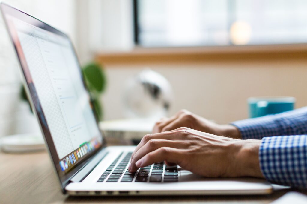 Person typing on a laptop while working on an email marketing campaign for a campground.